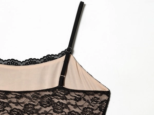 Dettaglio del vestito in pizzo nero con spalline regolabili e fibbie in metallo