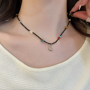 Close-up of handmade beaded necklace with natural stones and snail pendant
