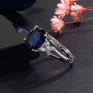 Elegant adjustable silver ring featuring a large oval blue sapphire and zircon accents