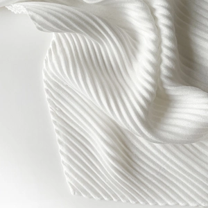 Close-up of white pleated faux linen scarf fabric showing detailed texture and soft folds