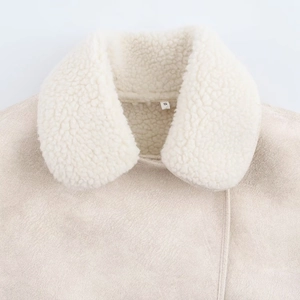 Close-up detail of beige faux shearling collar and soft lining texture on women jacket