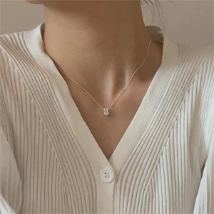 Minimalist 925 sterling silver bunny pendant necklace worn by a model on white