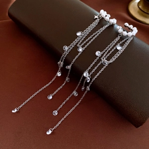 Detail of silver long tassel earrings with white pearls and sparkling zircons