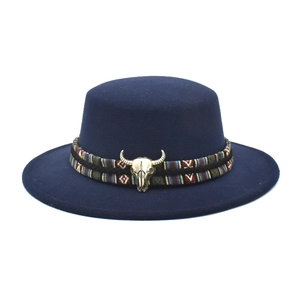 Detail of navy wool felt fedora featuring ethnic woven band and bronze bull skull buckle