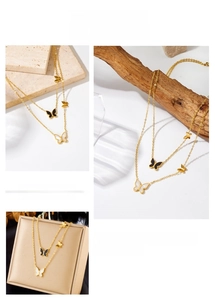 Detail of layered gold stainless steel necklace with black and white butterfly charms