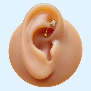 Gold curved barbell piercing with teardrop zircon and round bead shown on an ear model