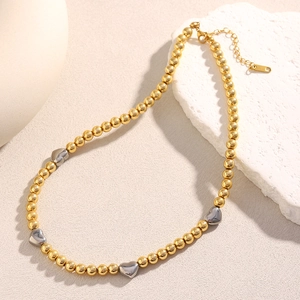 Dettaglio della collana di perline bicolore placcata oro 18K con ciondoli a cuore in argento