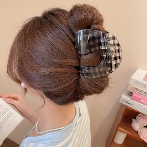 Close-up of a large black and white checkered acrylic hair claw clip for elegant bun styles