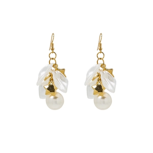 Close-up of white flower petals and cream pearls on elegant gold tassel earrings