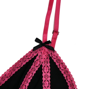 Close-up of black mesh fabric with pink lace trim and a small bow detail on the dress