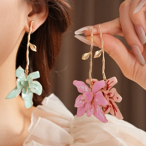 Detail of vintage flower earrings with green and pink enamel marble petals and golden stems