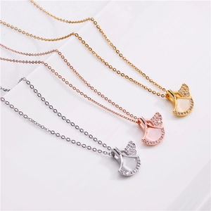 Detailed view of three fan-shaped ginkgo leaf necklaces in gold, silver, and rose gold