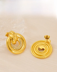 Detailed macro view of gold round stud earrings with double row sparkling zircon inlay