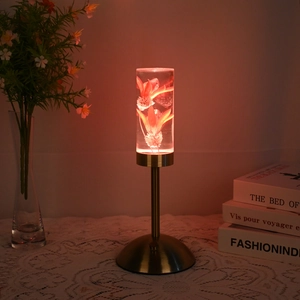 Close-up of preserved orange flowers inside a transparent acrylic LED table lamp shade
