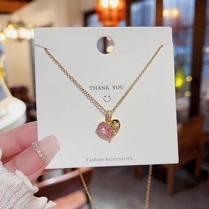 Détail du pendentif cœur en pierre rose avec métal ciselé doré sur chaîne fine