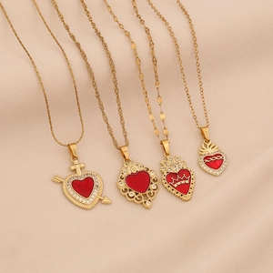 Gold stainless steel necklaces with various red zircon heart pendants on beige background