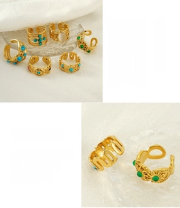 Detail of vintage stainless steel rings set with green stones and 18K gold plating