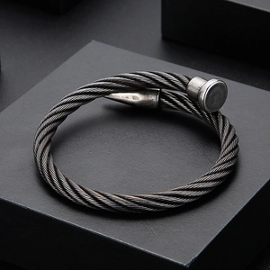 Close-up of industrial steel cable twist cuff bracelet in gunmetal grey finish