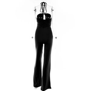 Rear view of black backless halter jumpsuit featuring wide leg pants and waist pleats