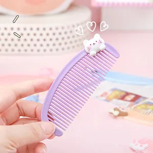 Cute purple mini moon comb with 3D cat topper held against a soft pink background