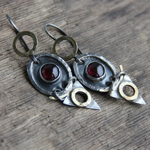 Vintage oxidized silver triangle earrings with red stone on rustic wood background
