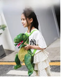 Close-up of a cute green dinosaur plush backpack with adjustable straps worn by a girl