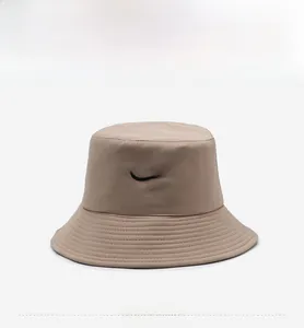 Detail of khaki cotton bucket hat featuring black embroidered bow and reinforced brim