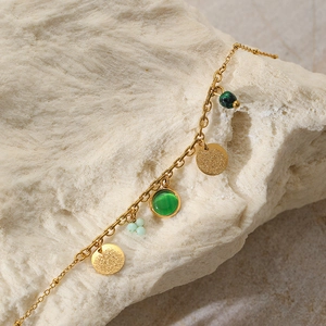 Dettaglio catena placcata oro 18K con gemme verdi e ciondoli a disco opachi