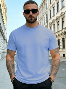 Close-up of light blue Henley neck cotton T-shirt worn by male model on a city street