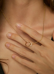 Close-up of gold double interlocking ring pendant necklace with pave crystal details