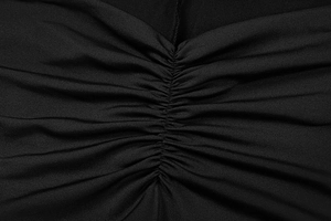 Detailed view of the central ruched texture and gathered design on the black knit dress