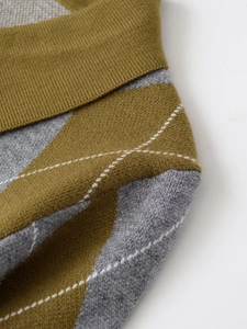 Close-up of argyle pattern knitwear with green and grey diamonds and white stitching