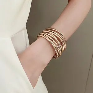 Minimalist multi-layered gold stacked bangle bracelet with elegant intertwined line design