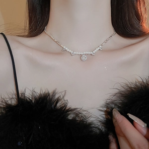 Détail du collier de perles et chaîne argentée avec pendentif cristal sur un mannequin