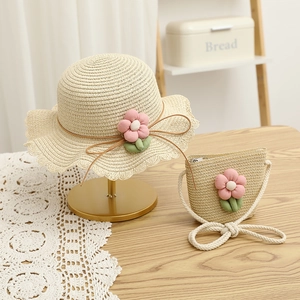 Detail of girls straw hat and matching floral bag set for summer outdoor wear