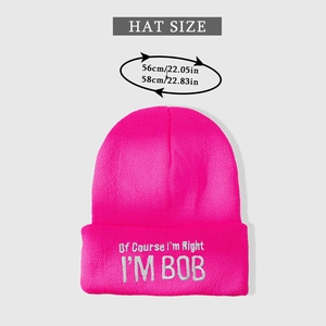 Close-up of bright pink knitted beanie with white embroidery and 56-58cm size details