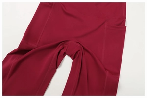 Primo piano di leggings da yoga rosso scuro con tasche laterali e cuciture rinforzate