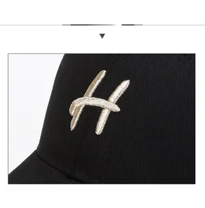Macro shot of 3D embroidered letter H on black cotton twill baseball cap texture
