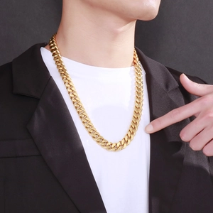 Male model wearing a 13mm gold Cuban link necklace with a black suit and white tee