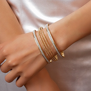 Multi-layer gold geometric bangle set with glitter finish and textured metal rings