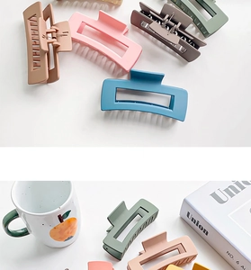 Flat lay of colorful matte rectangle hair claws with minimalist hollow design in pastel tones
