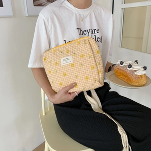 Detail of yellow checkered quilted pouch with smiley faces and soft cotton texture