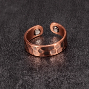 Detail of copper magnetic therapy ring with hammered texture and embedded magnets