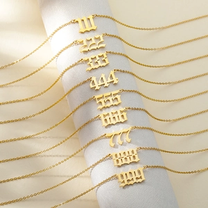Gold stainless steel angel number necklaces from 111 to 999 on white display