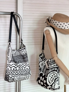 Detail of bohemian tote bags with abstract black and white patterns and leather straps