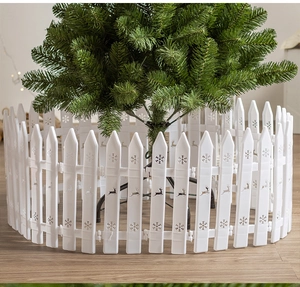 White Christmas tree fence detail with hollow snowflake and reindeer patterns on wood floor