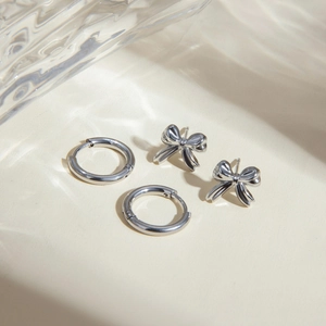 Silver stainless steel jewelry set featuring hoop earrings and elegant bow stud earrings