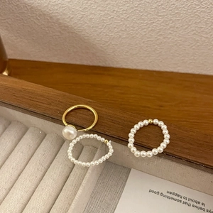 Detailed view of luxury freshwater pearl bead elastic rings on a wooden jewelry display