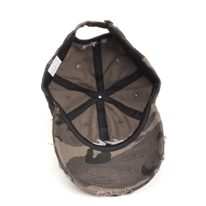 Detail view of 100% cotton washed camo baseball cap showing inner seams and fabric tag