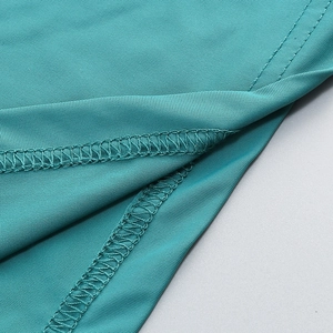 Close-up of teal halter dress showing fine knit texture and precision stitching